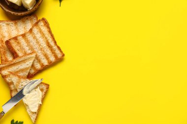 Sarı arka planda tereyağlı lezzetli tostlar.