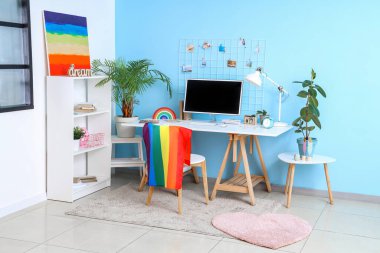Interior of office with workplace, LGBT flag and painting