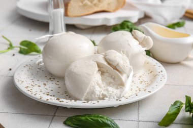 Beyaz fayanslı fesleğenli lezzetli Burrata peyniri tabağı
