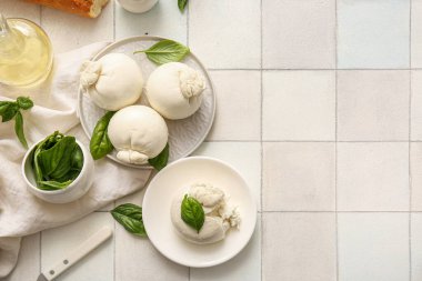Beyaz fayanslı fesleğen ve yağlı lezzetli Burrata peyniri tabakları