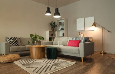 Gri koltukları ve parlak lambaları olan şık bir oturma odası.