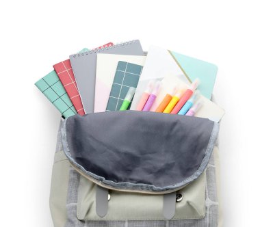 Beyaz arkaplanda izole edilmiş farklı kırtasiyeye sahip şık okul çantası, yakın plan