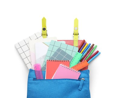 Farklı kırtasiyelere sahip renkli okul çantası beyaz arkaplanda izole edilmiş, yakın plan