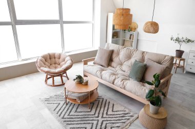 Koltuğu, koltuğu ve masası olan bir oturma odası.