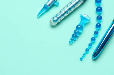 Turkuaz arka plandaki seks dükkanından farklı anal prizler ve vibratörler.