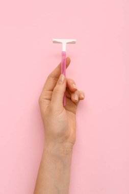 Pembe arka planda güvenlik jileti olan bir kadın el.