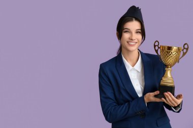 Leylak arka planında altın bardağı olan genç bir hostes.