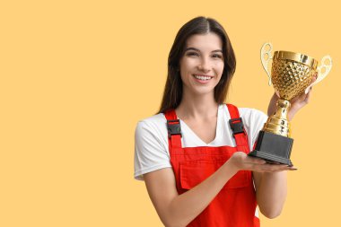 Sarı arka planda altın bardaklı kadın işçi.