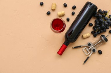 Bej arka planda üzümlü bir bardak ve bir şişe nefis şarap.