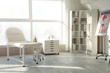 Kanepesi ve raf ünitesi olan bir tıp bürosu.