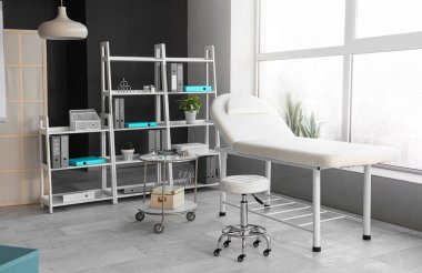 Kanepesi ve raf ünitesi olan modern tıp bürosu.