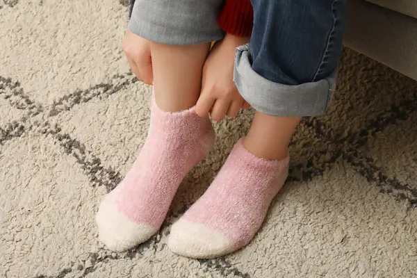 Woman in warm pink socks at home