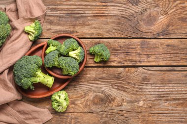 Ahşap tepsi ve kase ve ahşap arka planda taze yeşil brokoli.