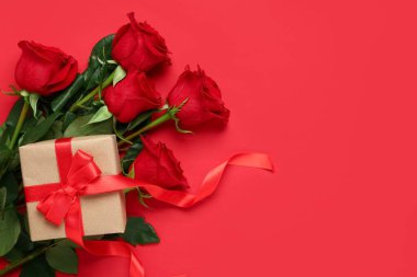 Kırmızı arka planda hediye kutusu olan güller. Sevgililer Günü konsepti