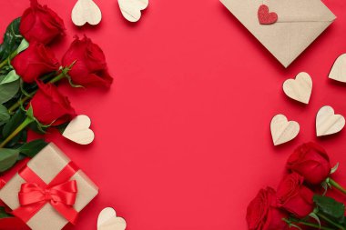 Hediyeli aşk mektubu çerçevesi, kırmızı arka planda ahşap kalpler ve güller. Sevgililer Günü konsepti
