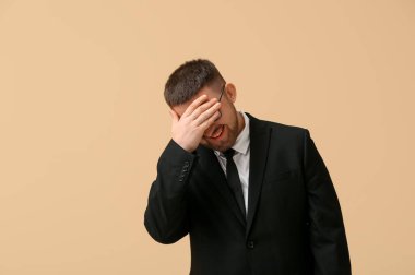 Bej arka planda yakışıklı mutlu genç iş adamı.