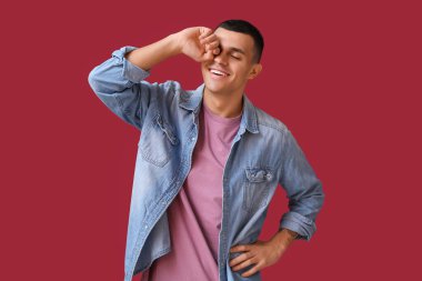 Kırmızı arka planda gülen mutlu genç adamın portresi