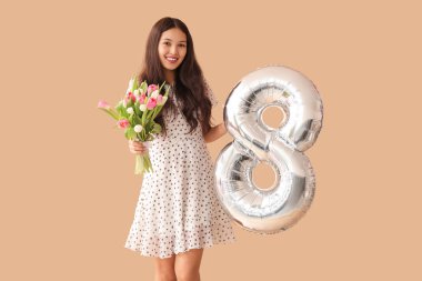 Gümüş renkli hava balonu olan güzel bir Asyalı kadın figür 8 ve kahverengi arka planda bir buket güzel lale. Uluslararası Kadınlar Günü