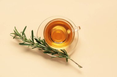 Bej arka planda bir bardak sıcak biberiye çayı.