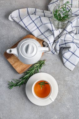 Gri arkaplanda bir fincan sıcak biberiye çayı.