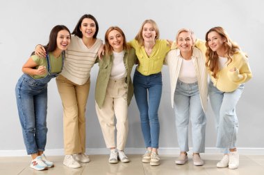 Gri duvarın yanında güzel sarılan kadınlar