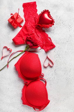 Kalp şeklinde balonu olan seksi kırmızı iç çamaşırı hediye kutusu ve grunge beyaz arka planda gül. Sevgililer Günü kutlaması