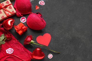 Kalp şeklinde balonları olan seksi kırmızı iç çamaşırı hediye kutuları ve grunge siyah arka planda güller. Sevgililer Günü kutlaması