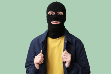 Yeşil arka planda kar maskeli yakışıklı bir genç.