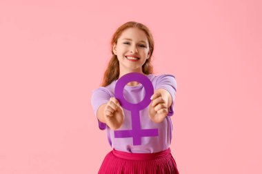 Pembe arka planda cinsiyet sembolü olan genç bir kadın.