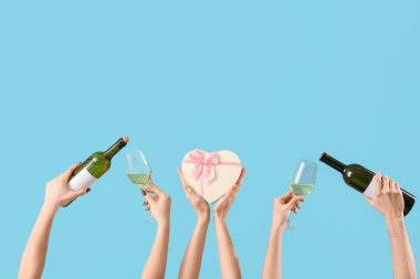 Mavi arka planda şarap ve hediye kutusu olan kadınlar. Sevgililer Günü kutlaması
