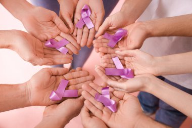 Pembe arka planda lavanta farkındalığı olan insanlar, yakın plan. Dünya Kanser Günü