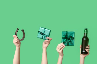 Biralı eller, hediyeler ve yeşil arka planda at nalı. Aziz Patrick Günü kutlaması