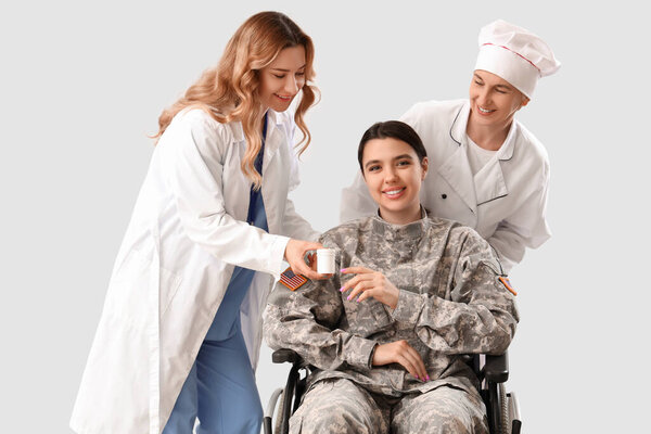 Women of different professions helping female soldier in wheelchair on grey background
