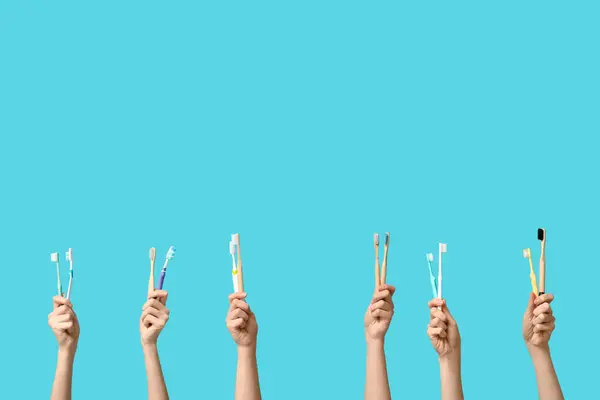 Weibliche Hände Mit Zahnbürsten Auf Blauem Hintergrund — Stockfoto