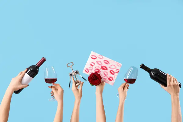 Women with wine, corkscrew, rose and lipstick kiss marks on blue background. Valentine\'s Day celebration