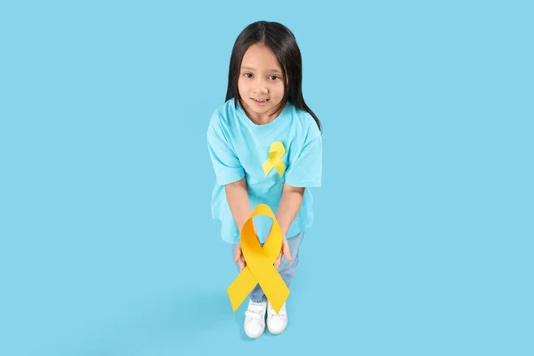 可爱的亚洲小女孩带着蓝色背景的黄色缎带 儿童癌症意识概念 — 图库照片