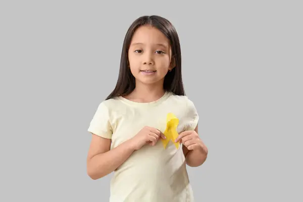 可爱的亚洲小女孩 灰色背景的黄色缎带 儿童癌症意识概念 — 图库照片
