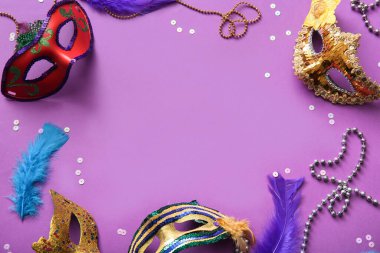 Mardi Gras kutlamaları için tüylü ve boncuklu karnaval maskelerinden yapılmış çerçeve mor arka planda