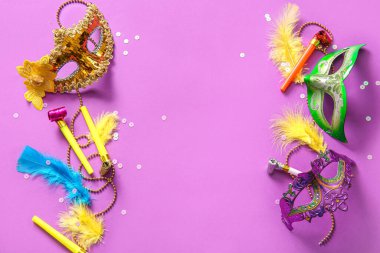 Mardi Gras için mor arka planda parti kornaları ve dekorları olan karnaval maskeleri.