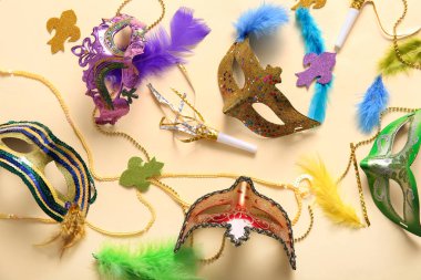 Mardi Gras için bej arka planda parti kornaları ve dekorları olan karnaval maskeleri.