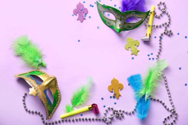 Mardi Gras kutlamaları için parti boynuzları ve dekorları olan karnaval maskeleri leylak arka planda