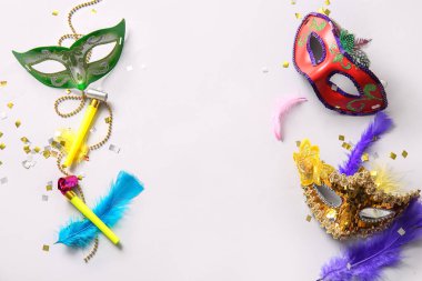 Karnaval maskeleri, parti kornaları ve Mardi Gras kutlamaları için dekorları beyaz arka planda.