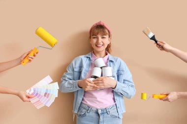 Bej arka planda tamir aletleri olan genç bir kadın ve eller.