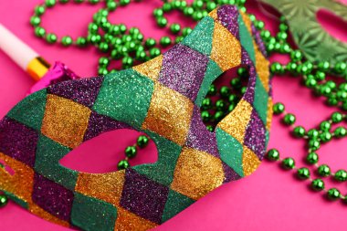 Mardi Gras için dekorlu karnaval maskesi pembe arka planda kutlanıyor