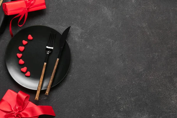 Sevgililer Günü için güzel bir masa. Hediyeler ve siyah arkaplanda kalpler.