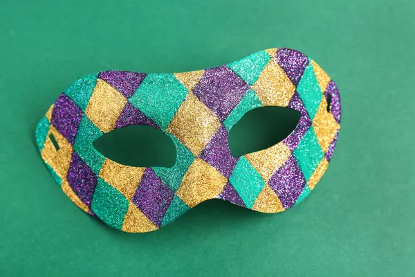 Mardi Gras kutlamaları için yeşil arka planda parlak karnaval maskesi