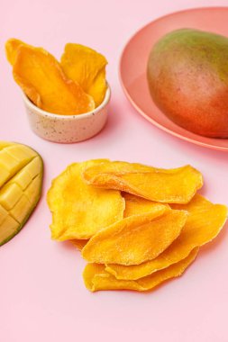 Pembe masada kurutulmuş mango dilimleri.