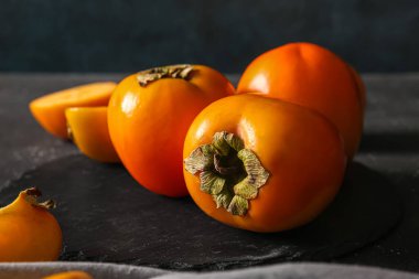 Siyah arkaplanda tatlı olgun hurma olan tahta