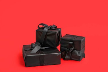 Kırmızı arkaplanda siyah hediye kutuları