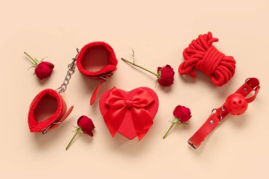 Seks oyuncaklarıyla kompozisyon, hediye kutusu ve renkli arkaplanda gül çiçekleri. Sevgililer Günü kutlaması